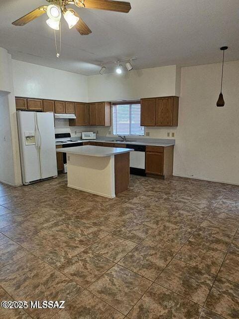 kitchen featuring under cabinet range hood, white appliances, a kitchen island, light countertops, and decorative light fixtures