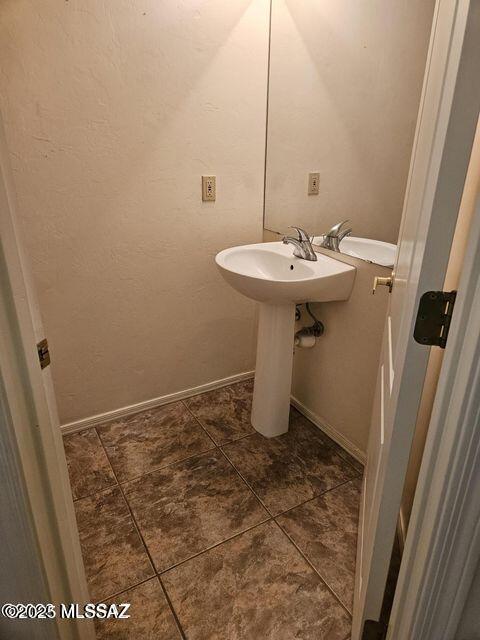 bathroom with tile patterned flooring, baseboards, and a sink