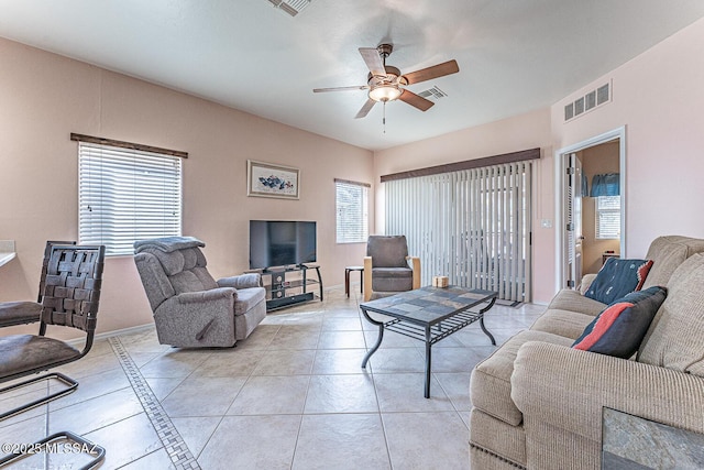 living room with a ceiling fan, light tile patterned flooring, visible vents, and baseboards