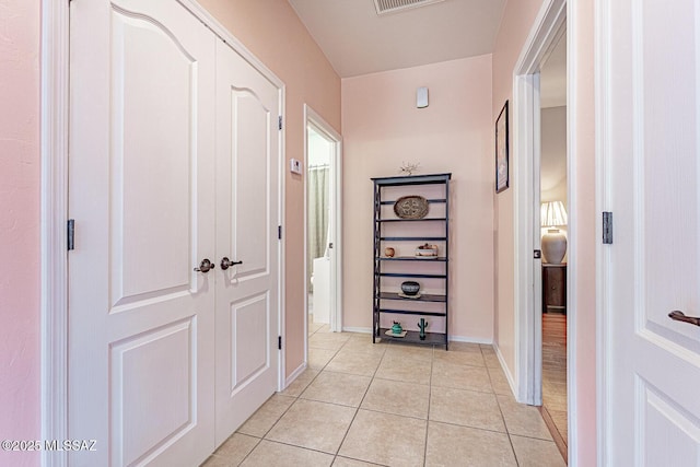 corridor with light tile patterned floors, baseboards, and visible vents