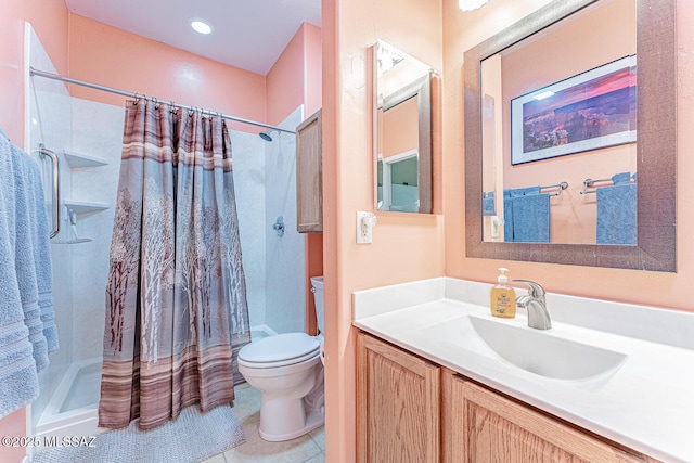 full bath featuring a stall shower, vanity, and toilet