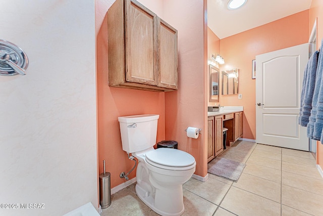 bathroom with toilet, vanity, baseboards, and tile patterned floors