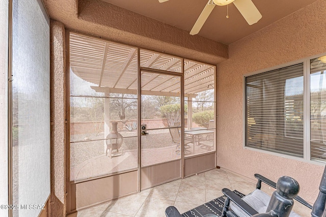 unfurnished sunroom featuring a ceiling fan