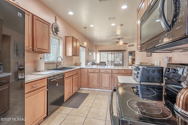 kitchen featuring light tile patterned floors, visible vents, a peninsula, black appliances, and a sink