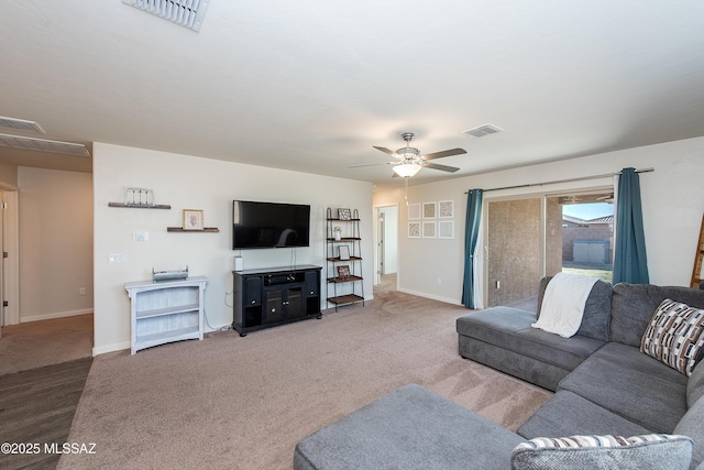 living room with baseboards, carpet floors, visible vents, and a ceiling fan