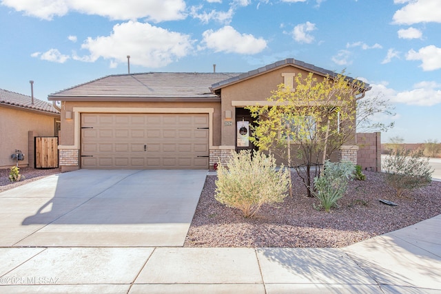 ranch-style house featuring an attached garage, fence, a tile roof, concrete driveway, and stucco siding