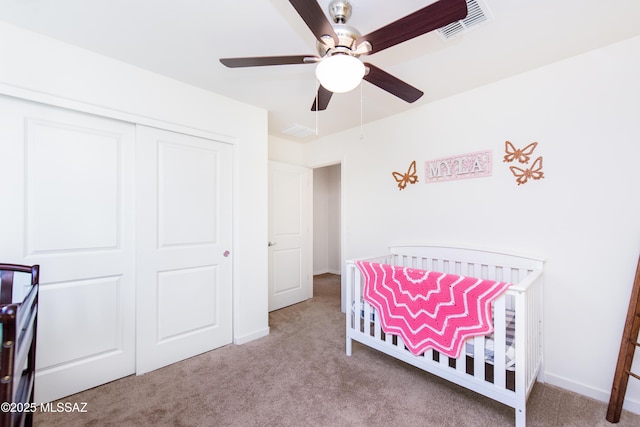 carpeted bedroom featuring ceiling fan, a closet, visible vents, and baseboards