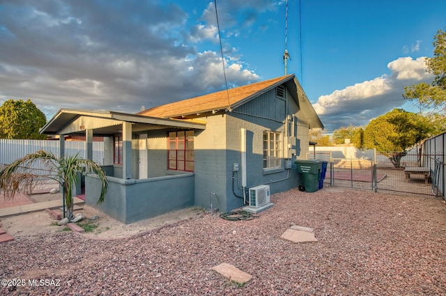 view of home's exterior featuring a gate, concrete block siding, and fence