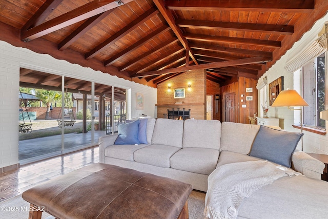 living area with tile patterned flooring, vaulted ceiling with beams, wood ceiling, and a warm lit fireplace