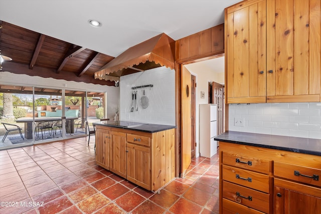 kitchen featuring dark countertops, tasteful backsplash, black electric stovetop, dark tile patterned floors, and wood ceiling