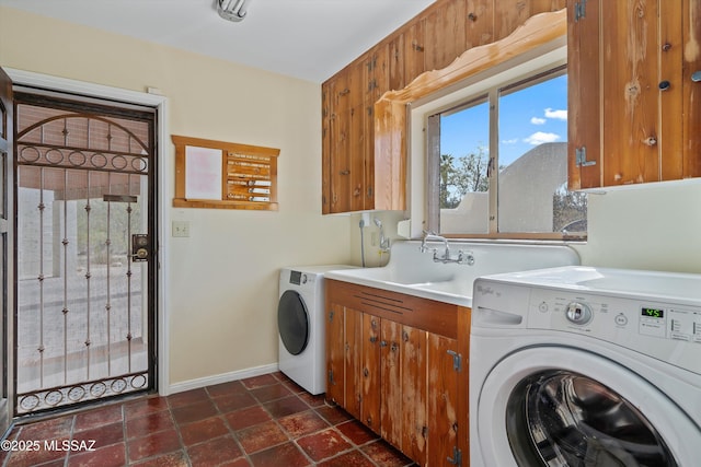 laundry room featuring washer and dryer, baseboards, cabinet space, and a sink