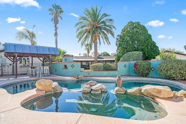 view of swimming pool featuring a patio area, a fenced in pool, an in ground hot tub, and fence