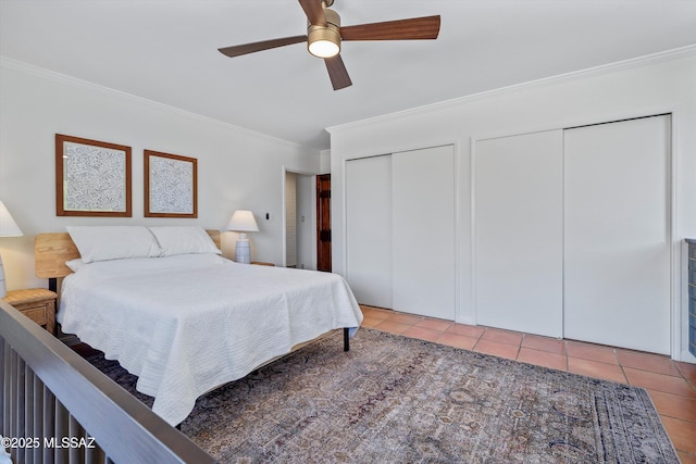 tiled bedroom with a ceiling fan, two closets, and ornamental molding