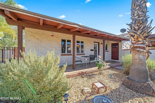 view of front of home with covered porch and fence