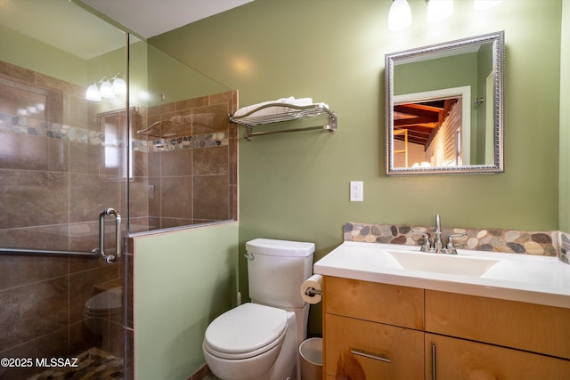 bathroom with a shower stall, toilet, and vanity