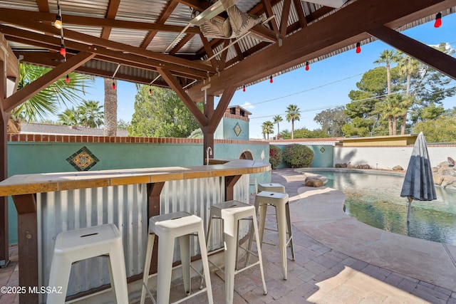 view of patio featuring a bar and an outdoor pool