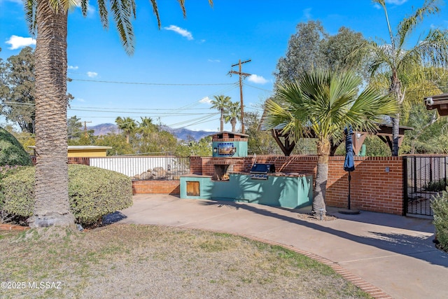 exterior space with an outdoor brick fireplace and fence