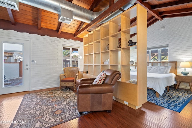 interior space featuring lofted ceiling with beams, wood ceiling, hardwood / wood-style floors, and brick wall