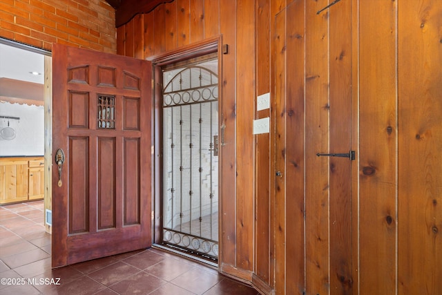 entrance foyer featuring dark tile patterned floors and wood walls