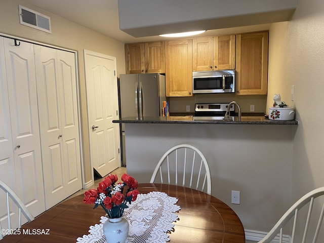 kitchen featuring a peninsula, visible vents, and appliances with stainless steel finishes