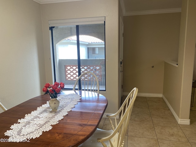 dining space featuring crown molding, light tile patterned flooring, and baseboards