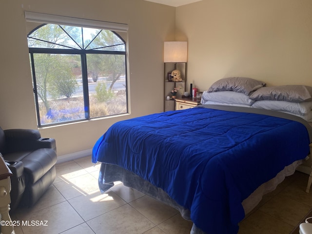 bedroom with light tile patterned floors and baseboards