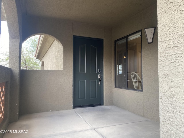 property entrance with stucco siding