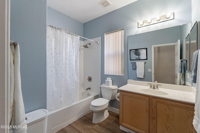 full bath featuring toilet, wood finished floors, visible vents, vanity, and shower / bath combo with shower curtain