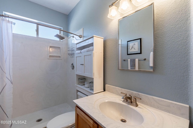 bathroom featuring toilet, a textured wall, vanity, and a shower with shower curtain