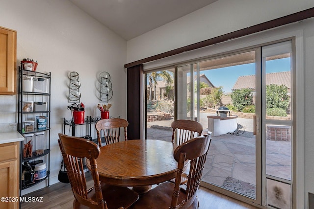 dining space featuring lofted ceiling and wood finished floors