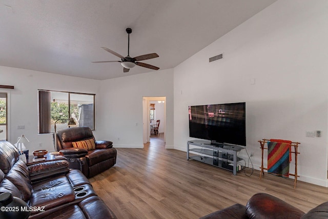 living area with lofted ceiling, baseboards, a ceiling fan, and wood finished floors