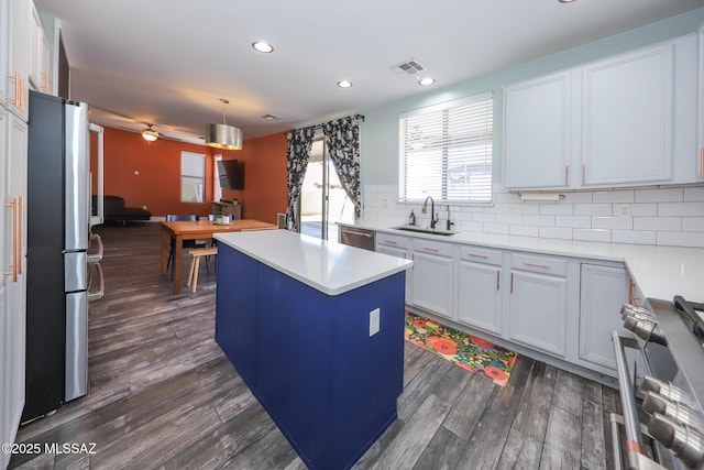 kitchen featuring recessed lighting, a sink, a kitchen island, backsplash, and stainless steel appliances