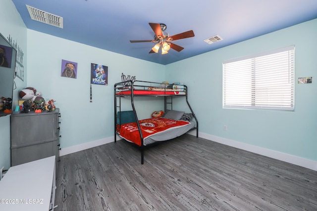bedroom with baseboards, visible vents, a ceiling fan, and wood finished floors