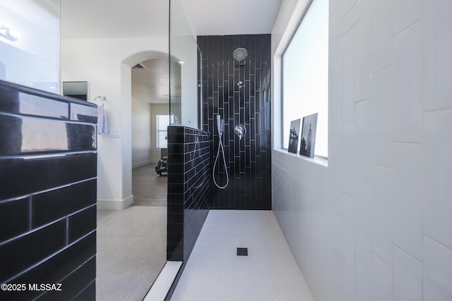 bathroom with walk in shower, tile patterned flooring, and baseboards