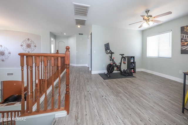 interior space featuring baseboards, ceiling fan, visible vents, and wood finished floors