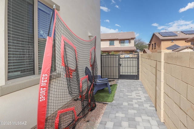 view of property exterior with stucco siding, fence, and a gate