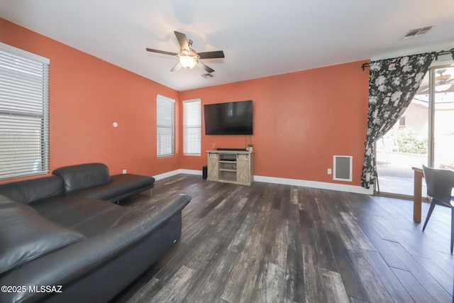 living area featuring dark wood-type flooring, baseboards, a ceiling fan, and visible vents