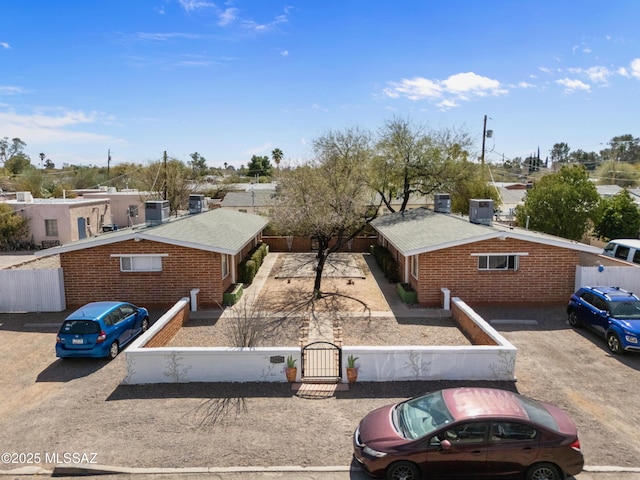 view of front of property with a fenced front yard, a gate, and central air condition unit