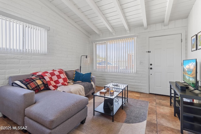 living area featuring tile patterned flooring, vaulted ceiling with beams, and brick wall