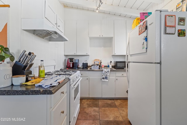 kitchen featuring dark tile patterned flooring, white appliances, dark countertops, and white cabinets