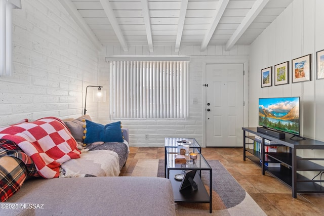 living area with lofted ceiling with beams and brick wall