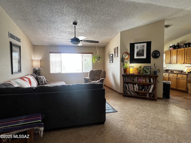 living area featuring a ceiling fan, visible vents, and a textured ceiling