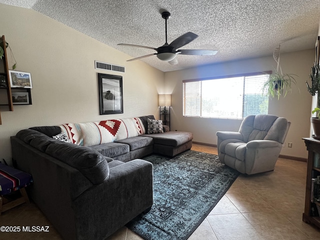 tiled living room featuring baseboards, visible vents, lofted ceiling, ceiling fan, and a textured ceiling