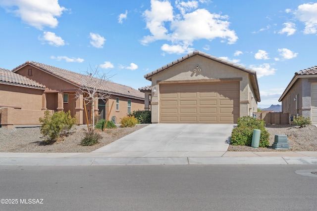 view of front of house with stucco siding, a garage, concrete driveway, and a tile roof