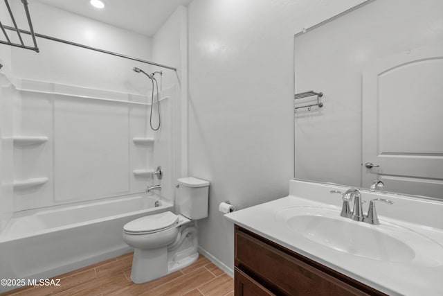 bathroom featuring wood finish floors, toilet, vanity, baseboards, and shower / bathtub combination