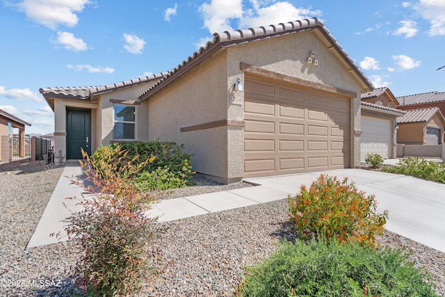 mediterranean / spanish-style house with a tile roof, concrete driveway, a garage, and stucco siding