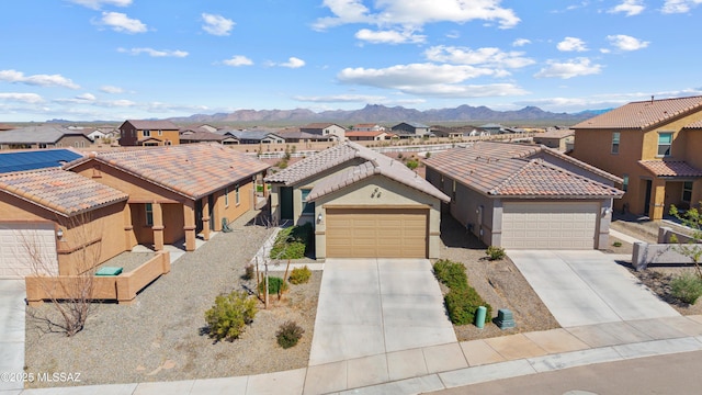 view of front of home featuring a residential view, stucco siding, a garage, a tile roof, and a mountain view