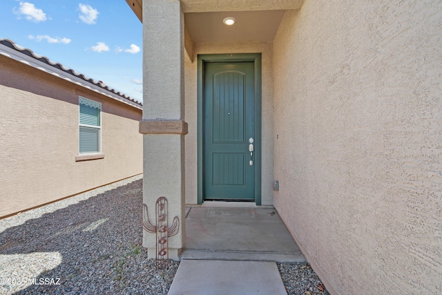 view of exterior entry with stucco siding