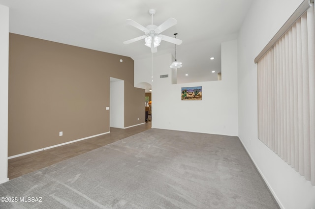 unfurnished living room featuring visible vents, arched walkways, carpet, and a ceiling fan