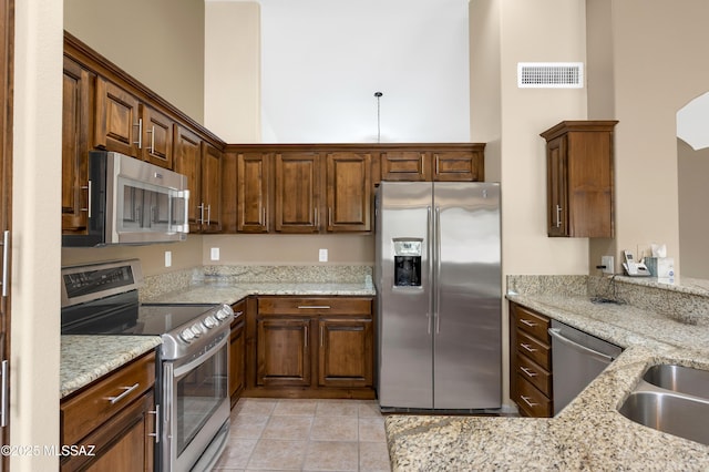 63606 E Desert Peak Dr, Tucson, AZ 85739 - kitchen featuring light stone counters, visible vents, appliances with stainless steel finishes, and a towering ceiling